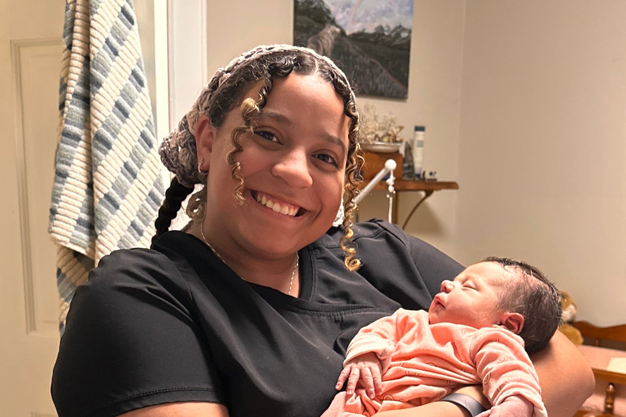 Woman holding a newborn baby in a home setting